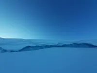 snow piled up on a small calving front of a lake-terminating glacier